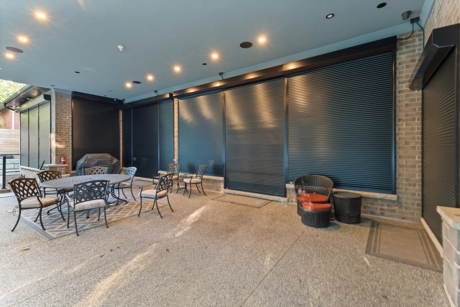 Wide covered patio enclosed with deployed aluminum roll shutters